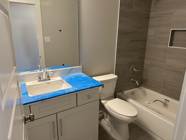 full bathroom with vanity, tiled shower / bath, and toilet