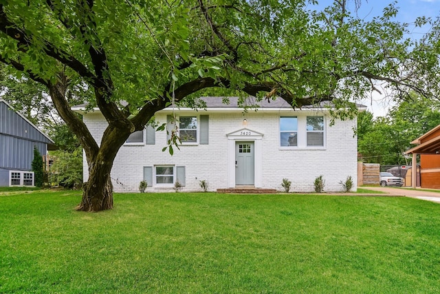 split foyer home featuring brick siding and a front yard