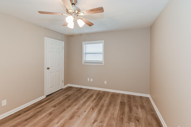 spare room with baseboards, ceiling fan, and light wood-type flooring