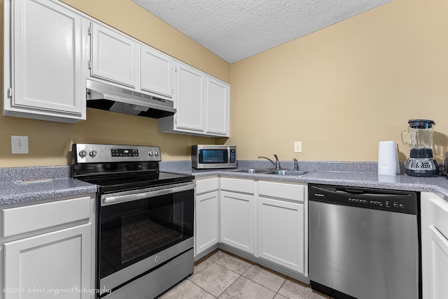 kitchen featuring light tile patterned flooring, sink, white cabinetry, a textured ceiling, and stainless steel appliances