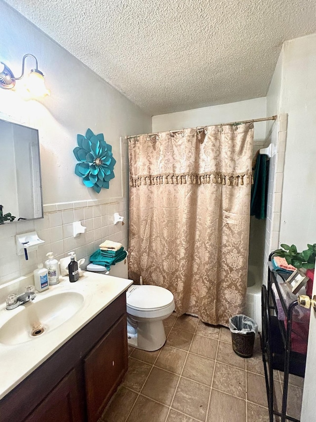 full bathroom featuring tile walls, toilet, a textured ceiling, and vanity