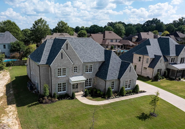 view of front of property with central air condition unit, a shingled roof, a front yard, and fence