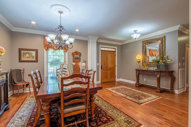 dining area featuring hardwood / wood-style floors, ornamental molding, and a notable chandelier