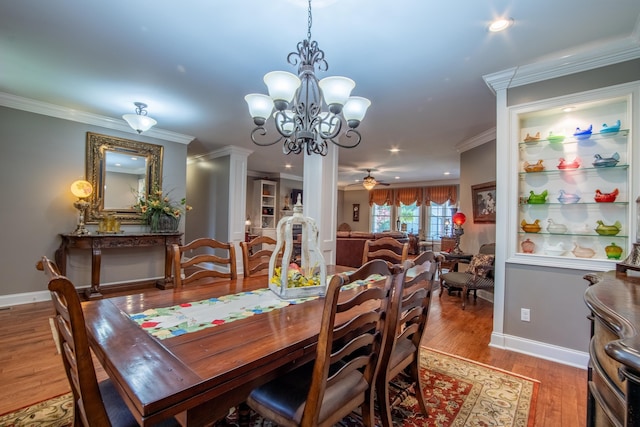 dining area with hardwood / wood-style floors, ceiling fan with notable chandelier, and crown molding