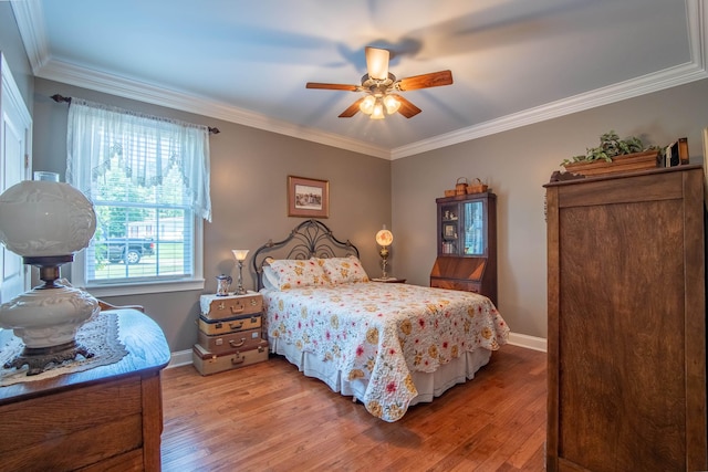 bedroom featuring ceiling fan, crown molding, and light hardwood / wood-style flooring