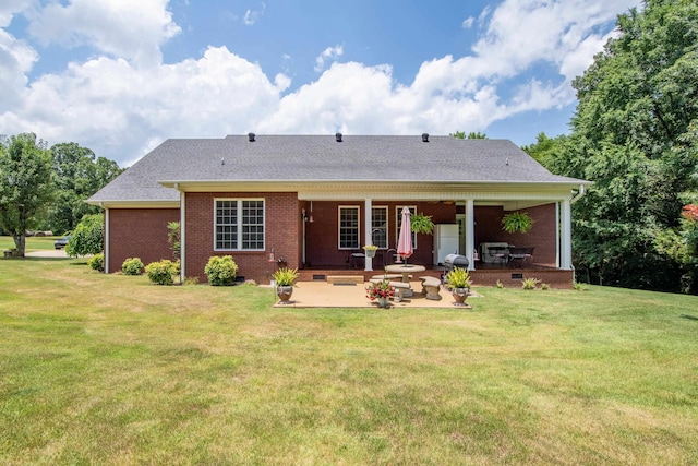 rear view of property with a patio and a lawn