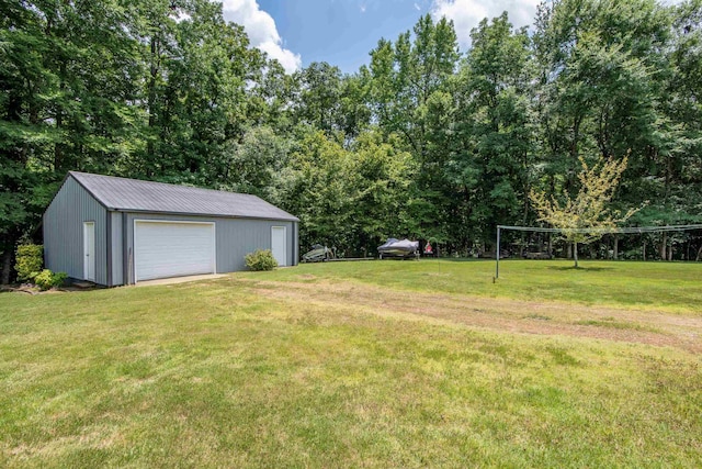 view of yard featuring a garage and an outbuilding