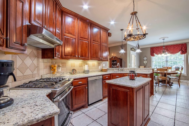 kitchen with stainless steel appliances, crown molding, an inviting chandelier, a center island, and hanging light fixtures