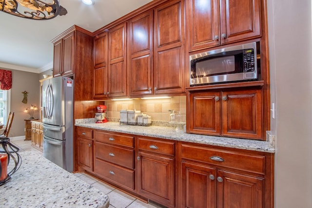 kitchen with stainless steel appliances, light stone counters, decorative backsplash, light tile patterned floors, and ornamental molding