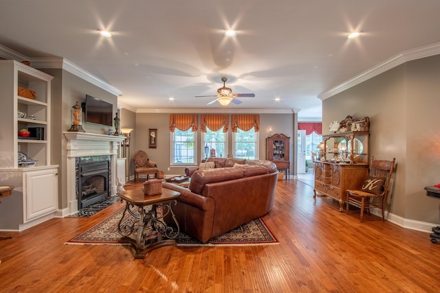 living room featuring a fireplace, light hardwood / wood-style floors, ceiling fan, and ornamental molding