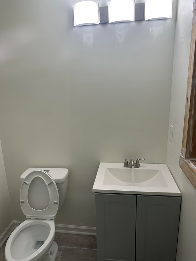 bathroom with tile floors, toilet, and vanity