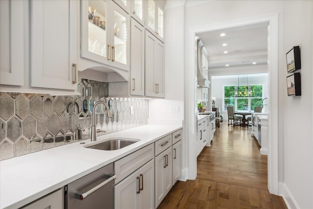 kitchen featuring dishwasher, white cabinetry, sink, backsplash, and dark hardwood / wood-style floors