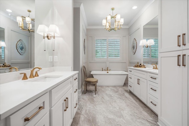 bathroom featuring a tub to relax in, vanity, ornamental molding, and a chandelier