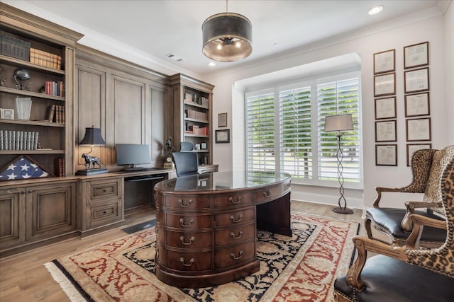 office area featuring light wood-type flooring and ornamental molding