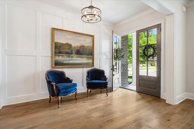 sitting room featuring an inviting chandelier and hardwood / wood-style floors