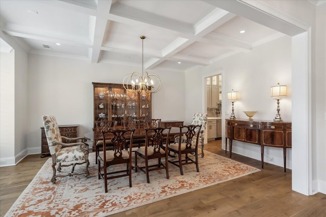 dining room with dark hardwood / wood-style floors, beam ceiling, a notable chandelier, and coffered ceiling