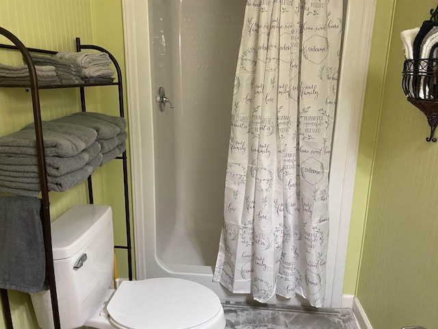 bathroom featuring toilet and curtained shower