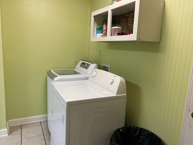 laundry area with washer and clothes dryer and light tile patterned floors