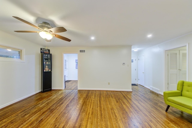 interior space featuring dark wood-style floors, baseboards, visible vents, and crown molding