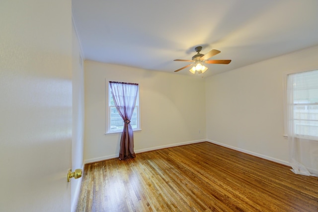 spare room with a ceiling fan, baseboards, and wood finished floors