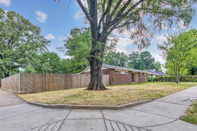 single story home featuring a carport and a front lawn