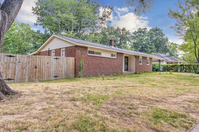 ranch-style home featuring a front yard and a carport