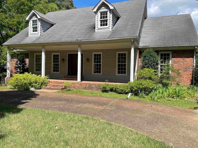 new england style home with a front lawn and a porch