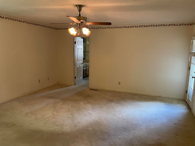 carpeted spare room featuring a textured ceiling and ceiling fan