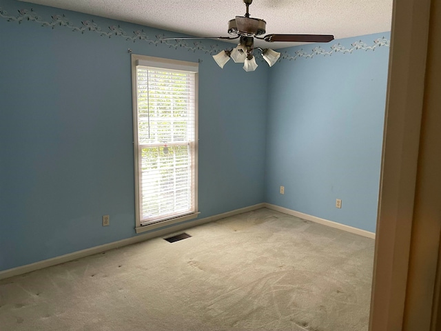 spare room featuring ceiling fan, a textured ceiling, and carpet floors