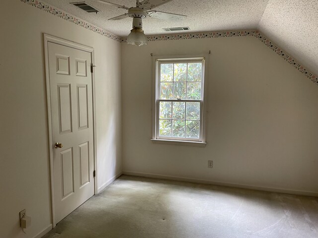 additional living space featuring ceiling fan, a textured ceiling, and lofted ceiling