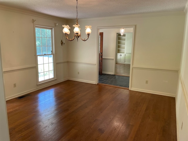 tiled spare room with a wealth of natural light, an inviting chandelier, ornamental molding, and a textured ceiling