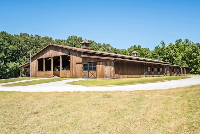 view of horse barn with a lawn