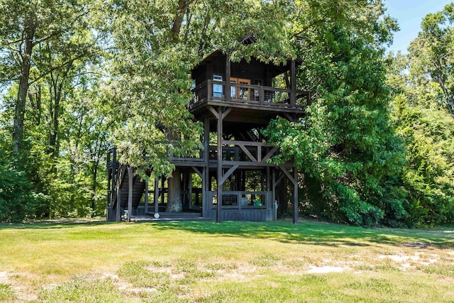 back of house with a balcony and a lawn