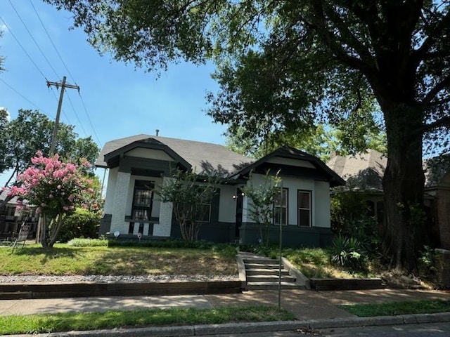 bungalow-style house with a front lawn