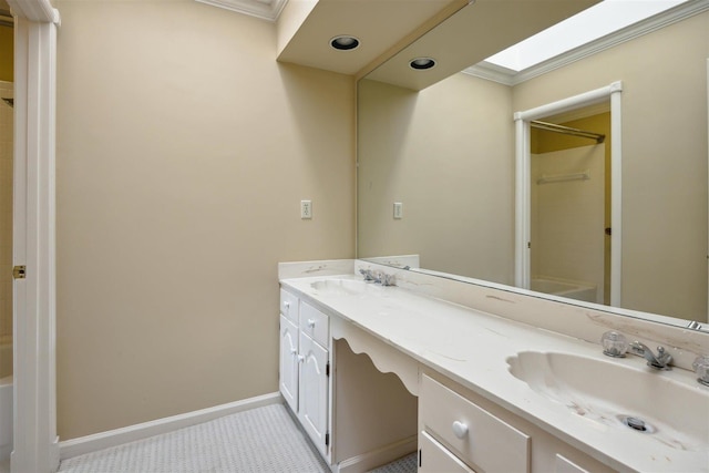 bathroom with ornamental molding, a skylight, tile patterned flooring, and vanity