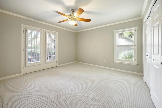 carpeted empty room featuring crown molding, french doors, and ceiling fan