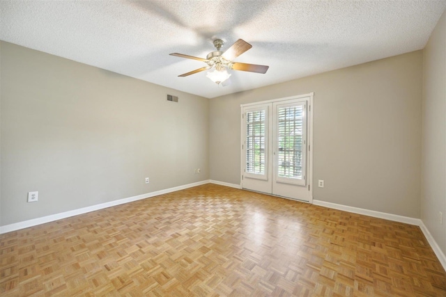 unfurnished room with ceiling fan, light parquet flooring, and a textured ceiling