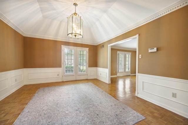 empty room featuring parquet flooring, ornamental molding, french doors, and a chandelier