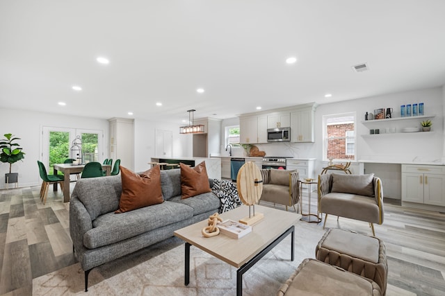 living area featuring visible vents, recessed lighting, and light wood-style floors