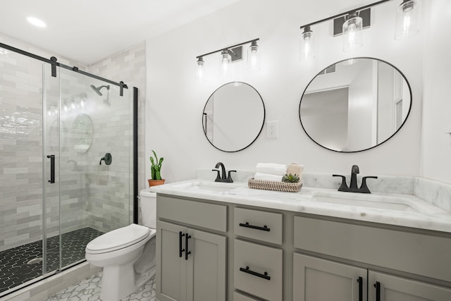 bathroom featuring tile patterned floors, a shower with door, toilet, and dual bowl vanity