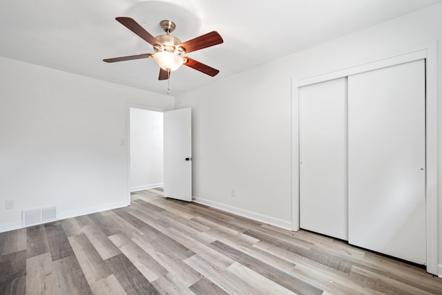 unfurnished bedroom with light wood-style flooring, visible vents, baseboards, a closet, and a ceiling fan