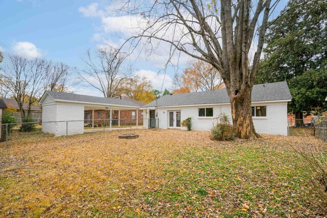 back of property featuring french doors, a chimney, a fenced backyard, and brick siding