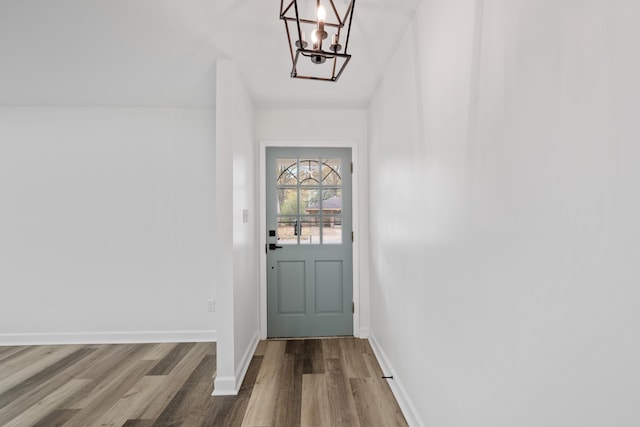 doorway to outside featuring an inviting chandelier and hardwood / wood-style flooring