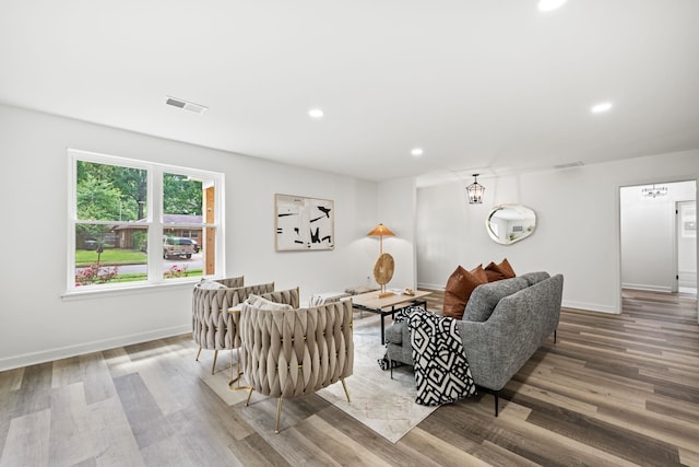 living room featuring baseboards, visible vents, wood finished floors, and recessed lighting