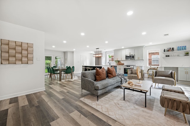living area featuring visible vents, recessed lighting, wood finished floors, and a healthy amount of sunlight
