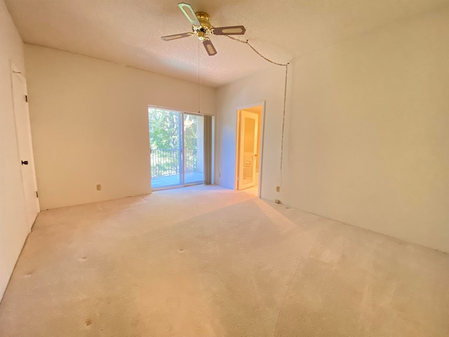 carpeted spare room featuring a textured ceiling and ceiling fan