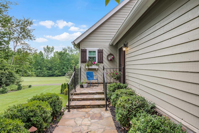 entrance to property featuring a lawn