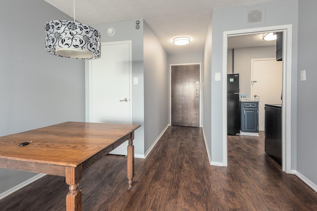 corridor with a textured ceiling and dark hardwood / wood-style flooring