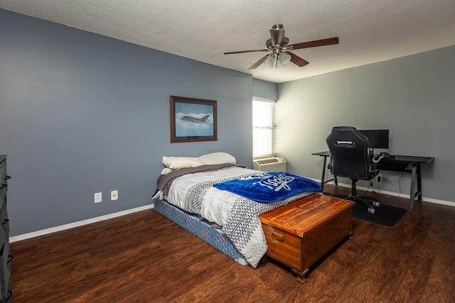 bedroom featuring ceiling fan, hardwood / wood-style floors, a textured ceiling, and an AC wall unit