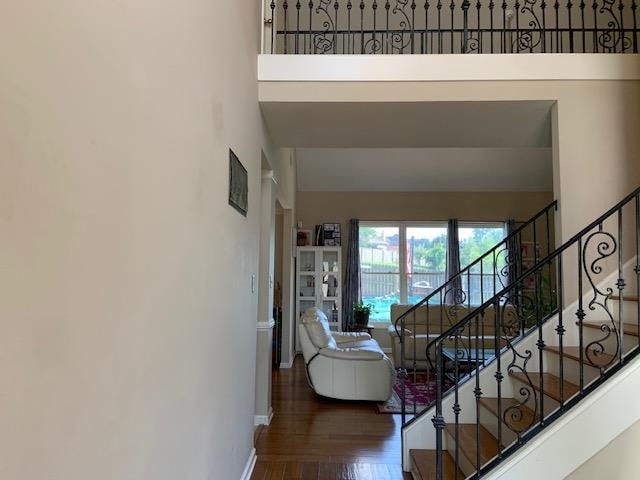 foyer entrance with hardwood / wood-style flooring and a towering ceiling